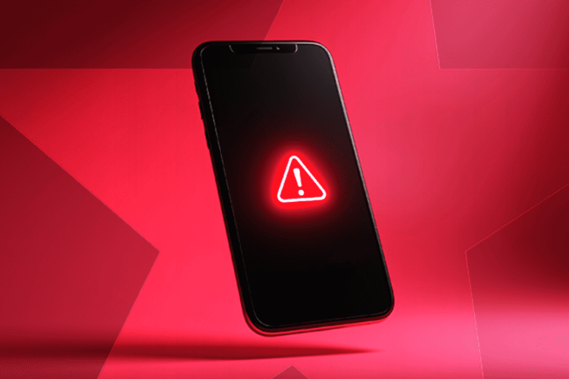 Smartphone displaying a glowing red neon warning triangle alert icon on a red background – Bet Blocker app features and how to block gambling access on mobile