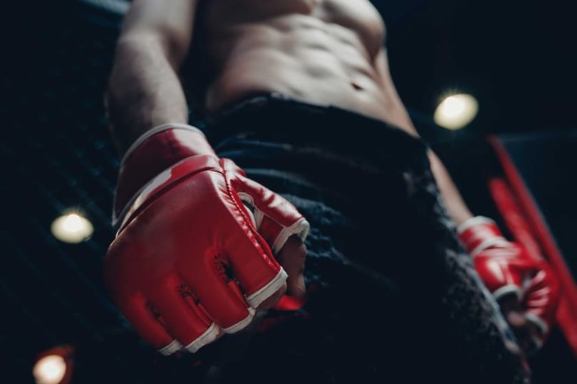 A UFC fighter preparing for a fight, in red gloves